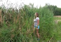 Young busty runner Adele licks a bean in the reeds