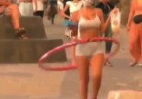 Chica scratching on the beach and twirling hoop with bags in hands