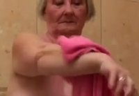 Granny with big tits washes her flabby body in the bathroom