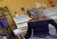 Pianista con falda y medias chupa y mira con su compañera