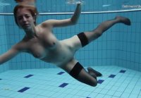 Anetta swims in the indoor pool in nylon stockings and corset